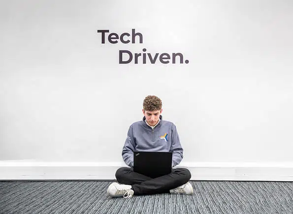 Alex sitting in front of the SEP2 "tech driven" wall