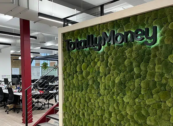 Moss wall in the TotallyMoney office with the totallymoney sign
