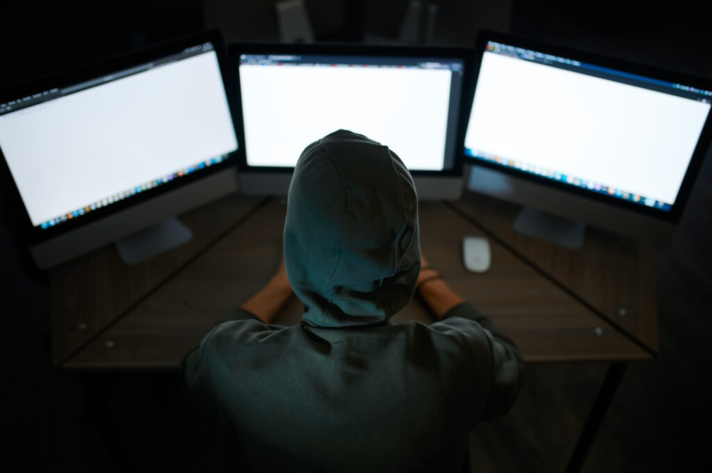 Hacker sitting at monitors
